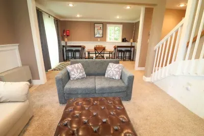 The game room! Featuring a sleeper sofa, 4 person table, and direct access to the back deck and patio.