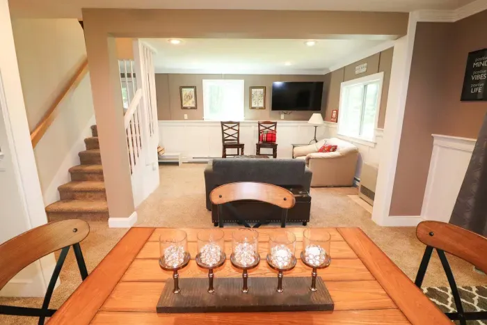 The game room! Featuring a sleeper sofa, 4 person table, and direct access to the back deck and patio.