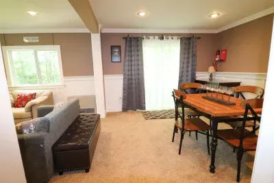 The game room! Featuring a sleeper sofa, 4 person table, and direct access to the back deck and patio.