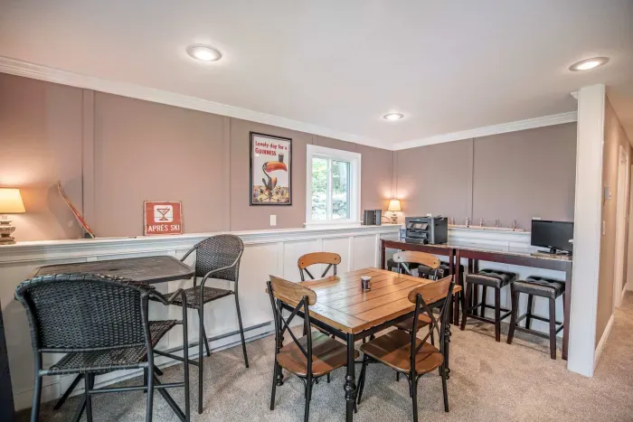 The game room! Featuring a sleeper sofa, 4 person table, and direct access to the back deck and patio.