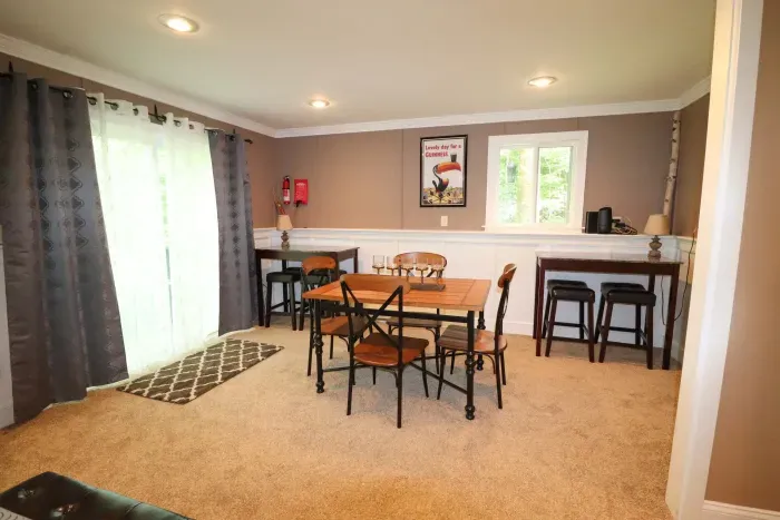 The game room! Featuring a sleeper sofa, 4 person table, and direct access to the back deck and patio.