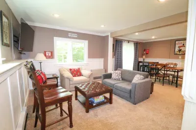 The game room! Featuring a sleeper sofa, 4 person table, and direct access to the back deck and patio.