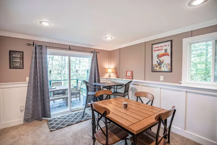 The game room! Featuring a sleeper sofa, 4 person table, and direct access to the back deck and patio.