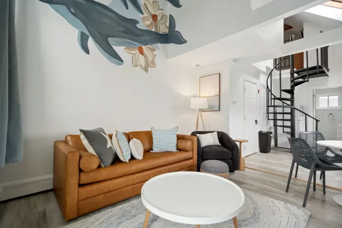 Cozy dining area and living room with 4-person dining table, sleeper sofa, smart TV, and access to private balcony