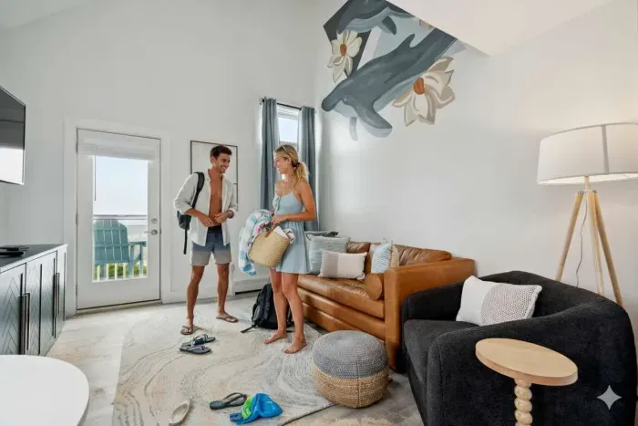 Cozy dining area and living room with 4-person dining table, sleeper sofa, smart TV, and access to private balcony