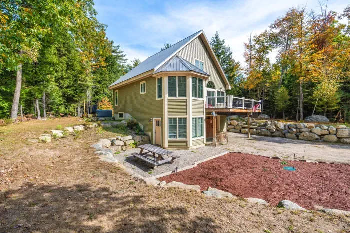 A side view of Mitten Pines Cabin, featuring the picnic table and large deck!
