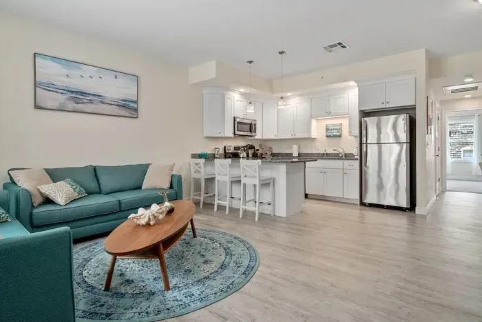 Open living room & kitchen with sleeper sofa, mounted smart TV, strong WiFi and fully-equipped kitchen