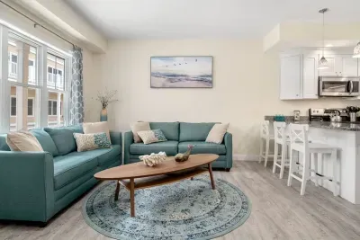 Open living room & kitchen with sleeper sofa, mounted smart TV, strong WiFi and fully-equipped kitchen