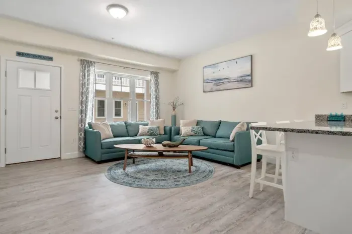 Open living room & kitchen with sleeper sofa, mounted smart TV, strong WiFi and fully-equipped kitchen