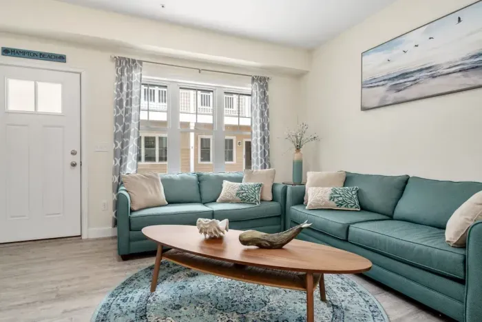 Open living room & kitchen with sleeper sofa, mounted smart TV, strong WiFi and fully-equipped kitchen