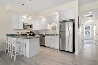 Open living room & kitchen with sleeper sofa, mounted smart TV, strong WiFi and fully-equipped kitchen