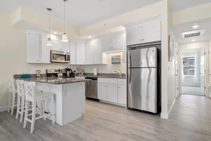 Open living room & kitchen with sleeper sofa, mounted smart TV, strong WiFi and fully-equipped kitchen