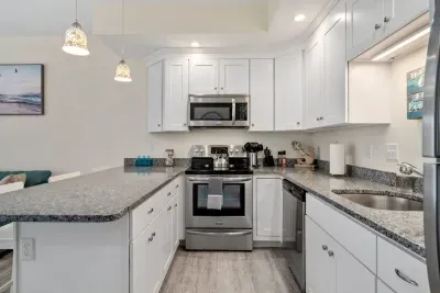 Open living room & kitchen with sleeper sofa, mounted smart TV, strong WiFi and fully-equipped kitchen