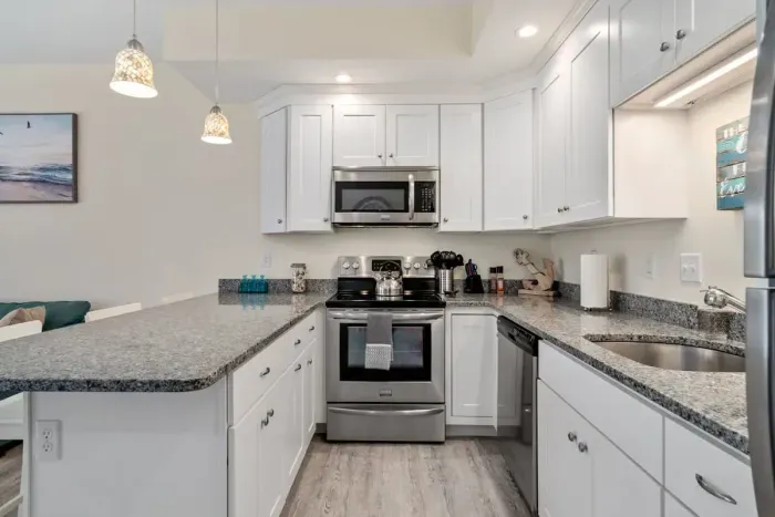 Open living room & kitchen with sleeper sofa, mounted smart TV, strong WiFi and fully-equipped kitchen