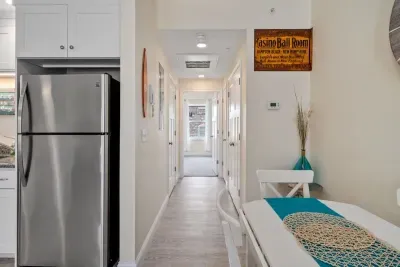 Open living room & kitchen with sleeper sofa, mounted smart TV, strong WiFi and fully-equipped kitchen