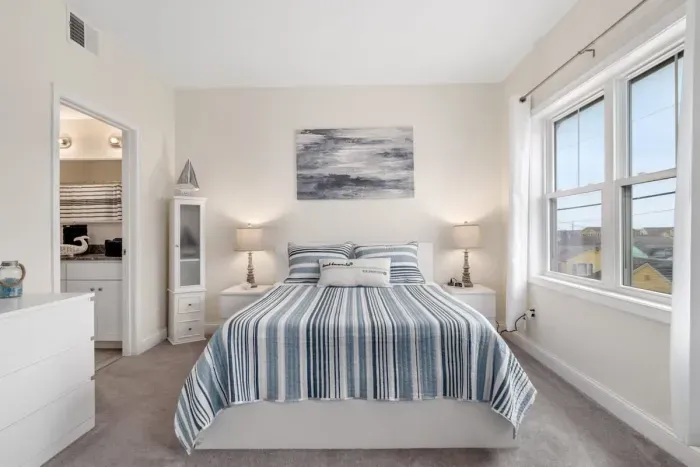 Bedroom with ensuite bathroom with double sink, stand up shower and stackable washer & dryer