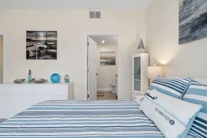 Bedroom with ensuite bathroom with double sink, stand up shower and stackable washer & dryer