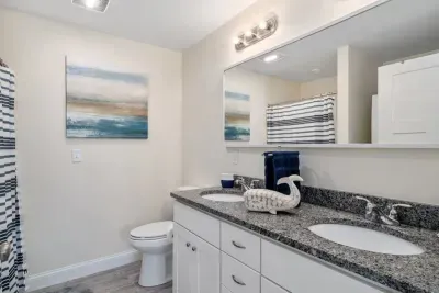 Bedroom with ensuite bathroom with double sink, stand up shower and stackable washer & dryer