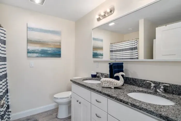 Bedroom with ensuite bathroom with double sink, stand up shower and stackable washer & dryer