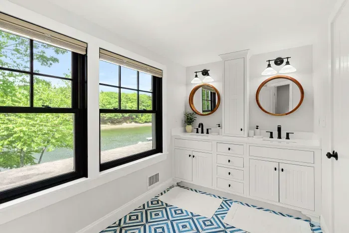 Fully renovated second-floor bathroom featuring dual sinks, a glass standing shower, water closet, and serene Sagamore Creek views. Fresh towels, shampoo, conditioner, and body wash all provided.