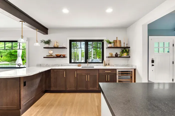 This stylish wet bar connects the kitchen to the outdoors through a fold-open accordion window, with outdoor bar seating right on the other side — plus a wine fridge and ice maker