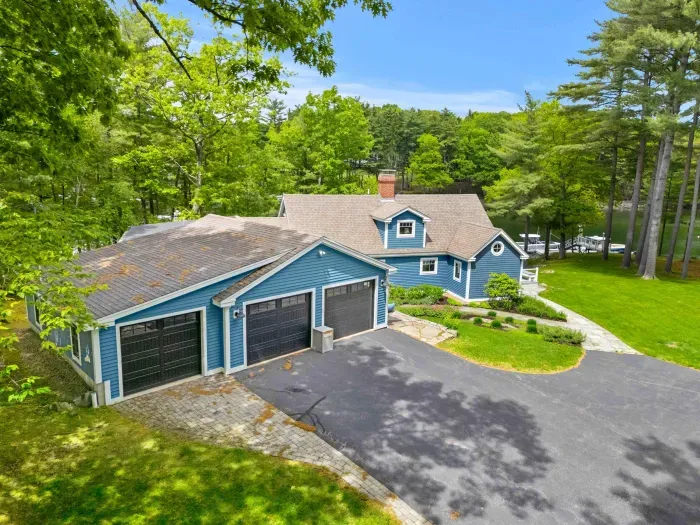 Back of the Creekhouse with driveway parking for up to four cars. The two right garage bays are available for guests — the leftmost bay is reserved as private storage.
