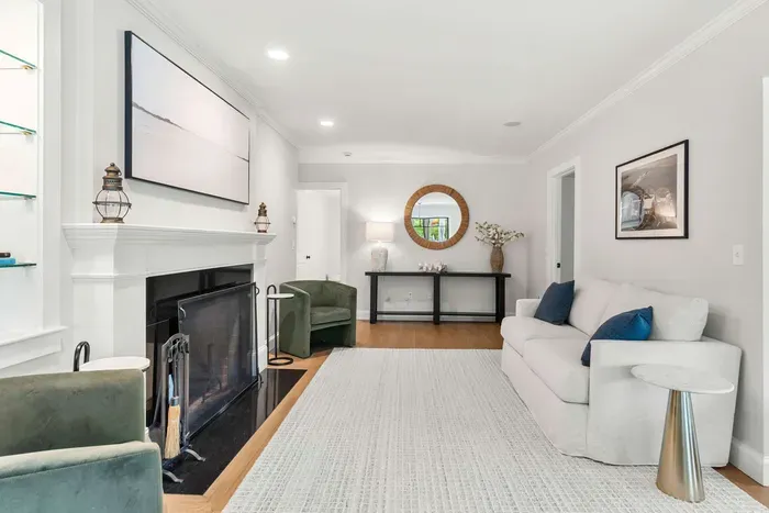 A cozy second living room located off the dining room featuring a love seat sofa and two chairs. Please note that the fireplace is not operable.