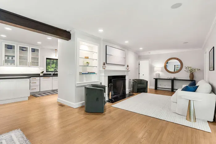 A cozy second living room located off the dining room featuring a love seat sofa and two chairs. Please note that the fireplace is not operable.