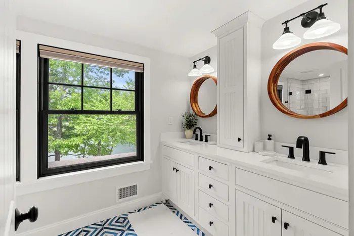 Fully renovated second-floor bathroom featuring dual sinks, a glass standing shower, water closet, and serene Sagamore Creek views. Fresh towels, shampoo, conditioner, and body wash all provided.
