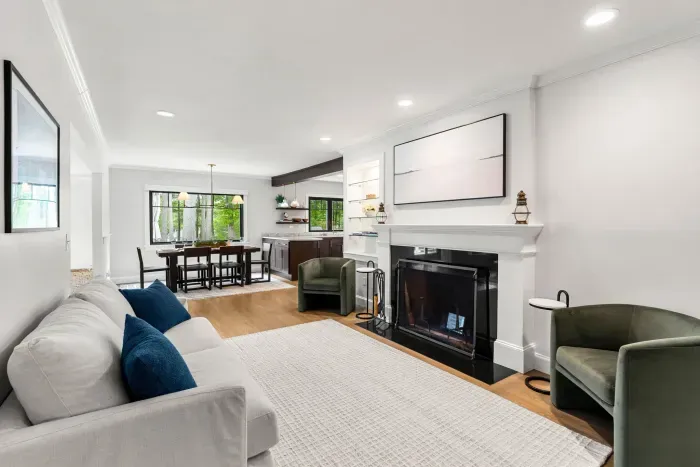 A cozy second living room located off the dining room featuring a love seat sofa and two chairs. Please note that the fireplace is not operable.