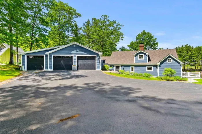 Back of the Creekhouse with driveway parking for up to four cars. The two right garage bays are available for guests — the leftmost bay is reserved as private storage.
