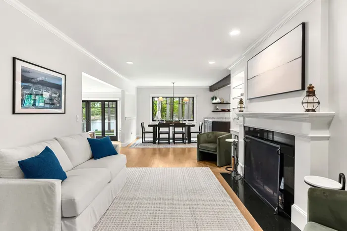 A cozy second living room located off the dining room featuring a love seat sofa and two chairs. Please note that the fireplace is not operable.