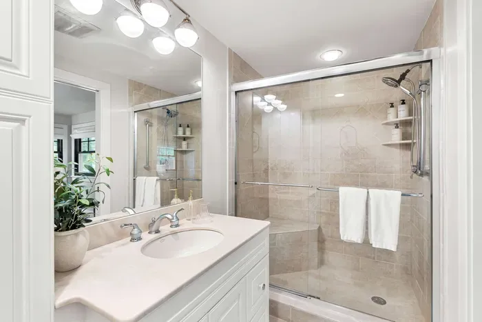 A full ensuite bathroom with a glass walk-in shower, fresh towels, and complimentary shampoo, conditioner, and body wash provided for your stay.