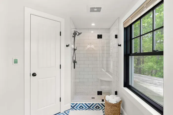 Fully renovated second-floor bathroom featuring dual sinks, a glass standing shower, water closet, and serene Sagamore Creek views. Fresh towels, shampoo, conditioner, and body wash all provided.