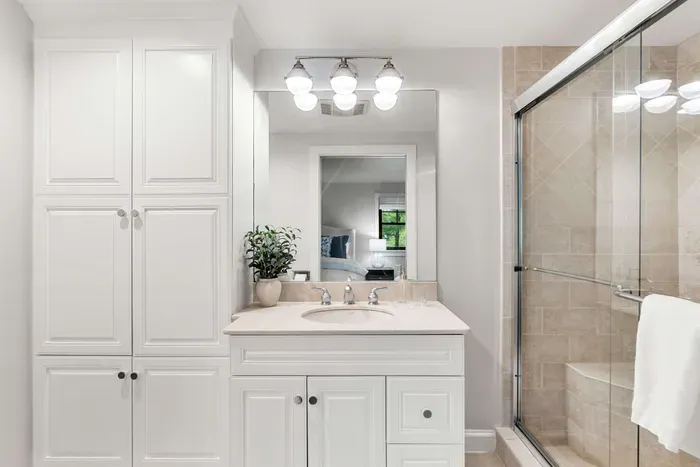 A full ensuite bathroom with a glass walk-in shower, fresh towels, and complimentary shampoo, conditioner, and body wash provided for your stay.