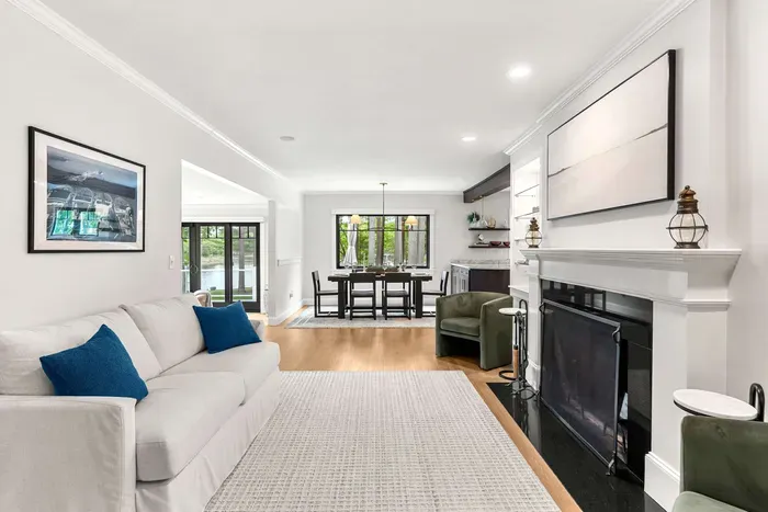 A cozy second living room located off the dining room featuring a love seat sofa and two chairs. Please note that the fireplace is not operable.