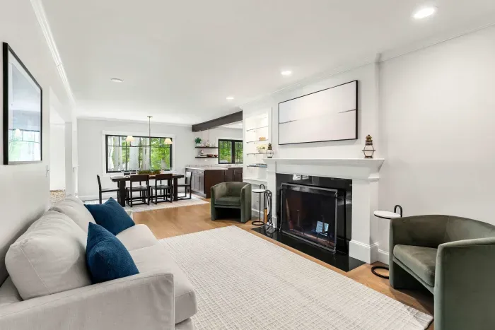 A cozy second living room located off the dining room featuring a love seat sofa and two chairs. Please note that the fireplace is not operable.