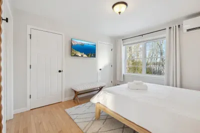 The Primary Bedroom! Clean linens provided. High quality, Thuma beds are in every Queen bedroom! There is a smart TV in this bedroom too! There are luggage racks in every bedroom!