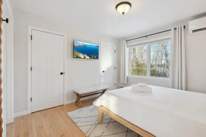 The Primary Bedroom! Clean linens provided. High quality, Thuma beds are in every Queen bedroom! There is a smart TV in this bedroom too! There are luggage racks in every bedroom!