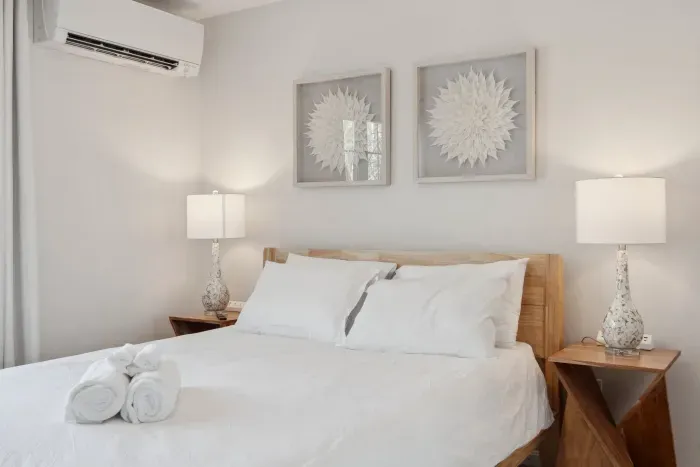 The Primary Bedroom! Clean linens provided. High quality, Thuma beds are in every Queen bedroom! There is a smart TV in this bedroom too! There are luggage racks in every bedroom!