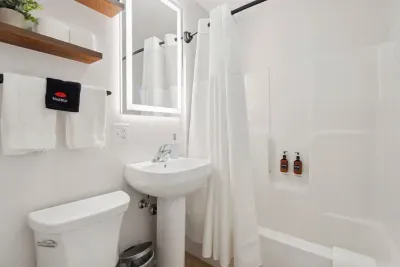 This bathroom is the ensuite for the Primary Bedroom. But it is also accessible off of the kitchen. There is a shower and tub combo. Clean towels provided for all guests