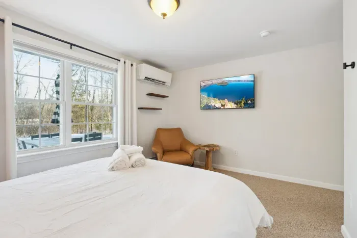 Bedroom #4 located on the downstairs level of the home. This room has a high quality Thuma Queen bed, luggage rack and smart TV! Clean linens provided