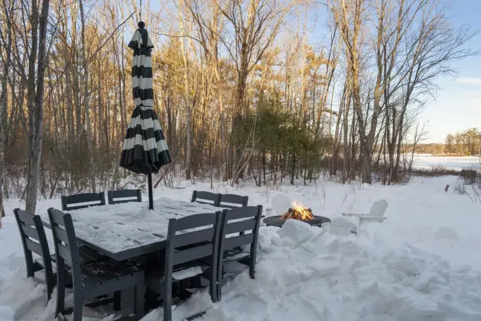 The backyard patio with seating for 8 at the table and 4 adirondack chairs by the fire!