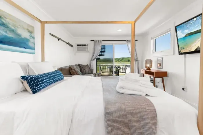 Bedroom with queen bed, sleeper sofa, work desk, smart TV and slider to private back deck