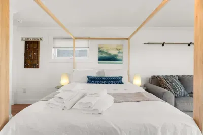 Bedroom with queen bed, sleeper sofa, work desk, smart TV and slider to private back deck