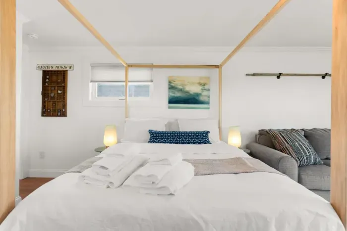 Bedroom with queen bed, sleeper sofa, work desk, smart TV and slider to private back deck