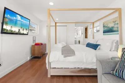Bedroom with queen bed, sleeper sofa, work desk, smart TV and slider to private back deck