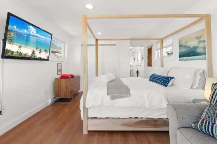 Bedroom with queen bed, sleeper sofa, work desk, smart TV and slider to private back deck