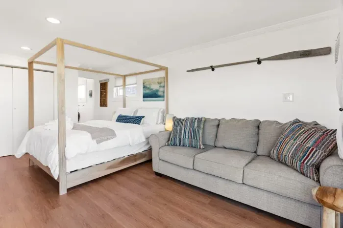 Bedroom with queen bed, sleeper sofa, work desk, smart TV and slider to private back deck