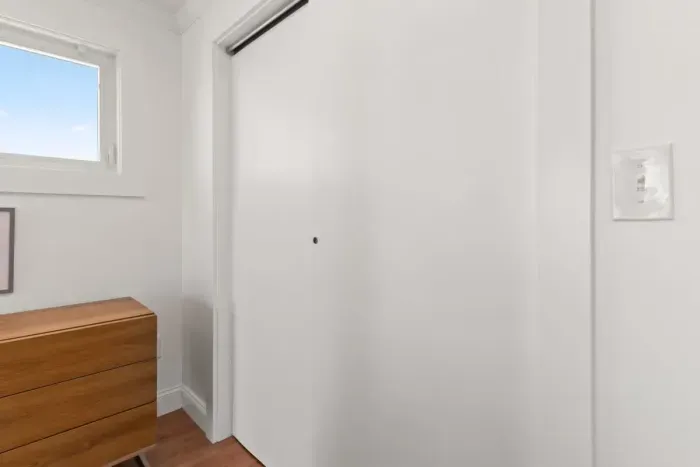 Bedroom with queen bed, sleeper sofa, work desk, smart TV and slider to private back deck